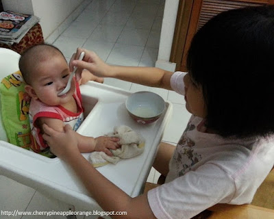 Cherry feeding Baby Orange formula milk with spoon