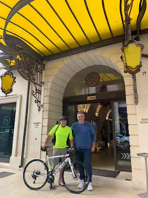 an American cyclist and the bike rental guy at the door of an historical hotel in the center of Lecce, Puglia region Southern Italy