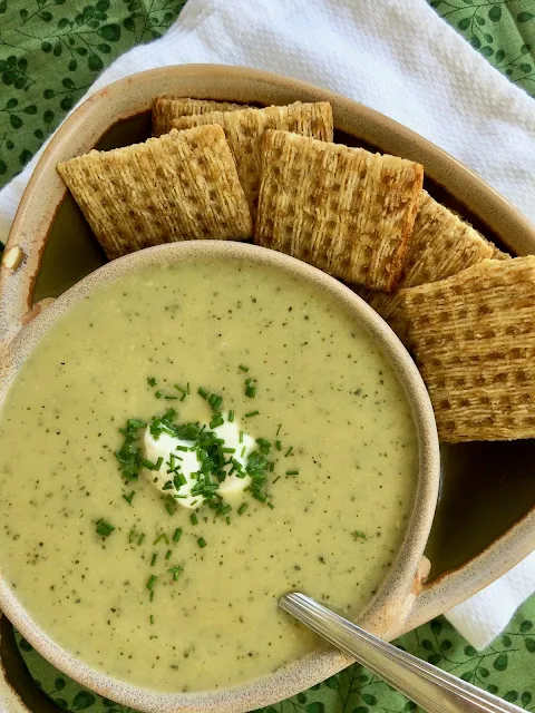 Finished bowl of zucchini soup topped with zucchini and chopped chives.