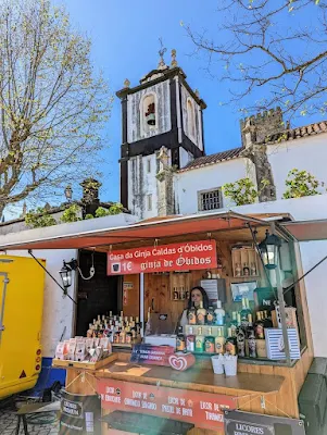 Vendor selling ginginha at the Obidos Chocolate Festival in Portugal