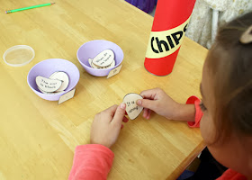 Tessa pulled paper potato chips from the "Chips" can, read the sentences and then placed them into the proper punctuation dip bowls.