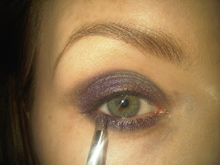 applying purple eyeshawdow under eyelids