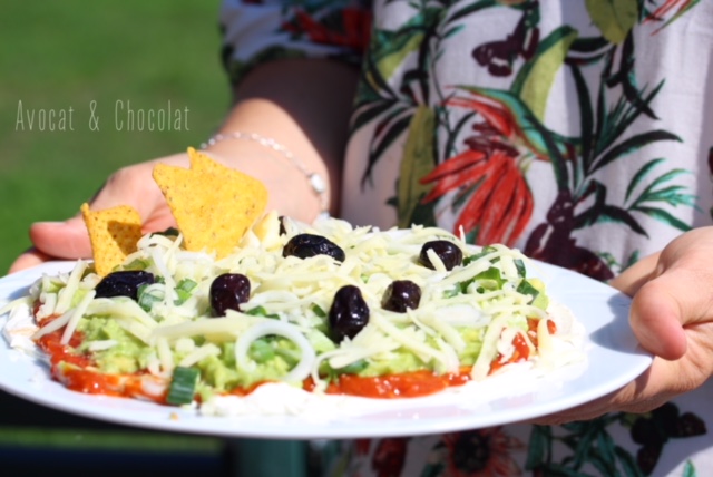 alt="femme en robe à fleur qui tient une assiette de pizza mexicaine"