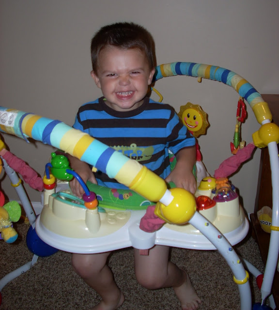 toddler squeezing in an exersaucer