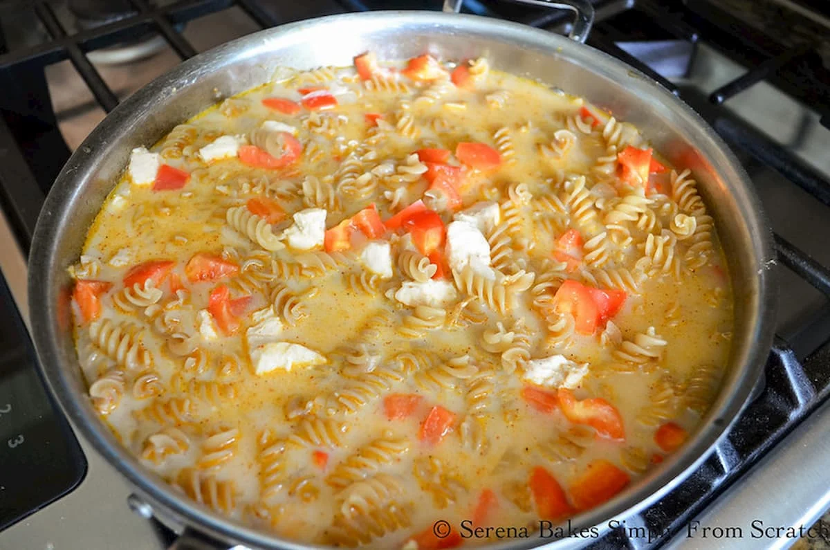 Chicken, Bell Pepper, Pasta, Chicken Stock, and Half and Half in a stainless steel pan.