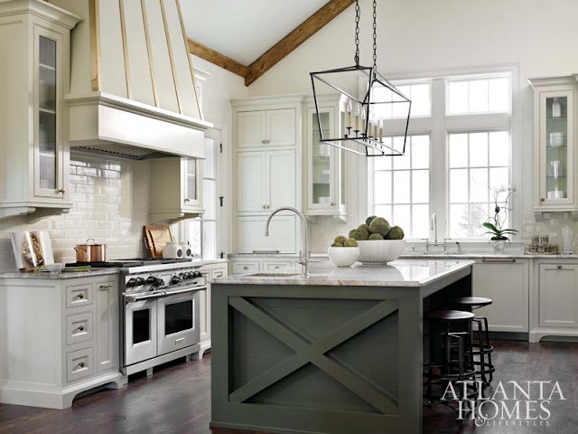 Gorgeous white kitchen with grey island, magnificent range hood, and professional range