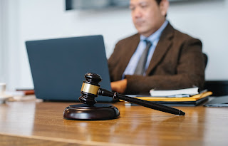 A man on a computer with a gavel | collection services Michigan