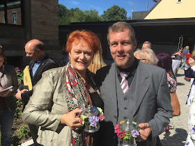 Catherine Foster with Georg Zeppenfeld on the forecourt of the Festspielhaus clutching their metal-coated inscribed beer tankards presented to them after five years' service - a Bayreuth tradition.