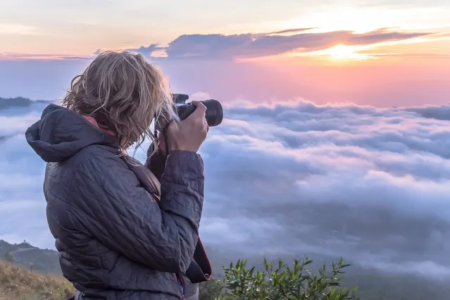 A girl photographing mountain view in asia