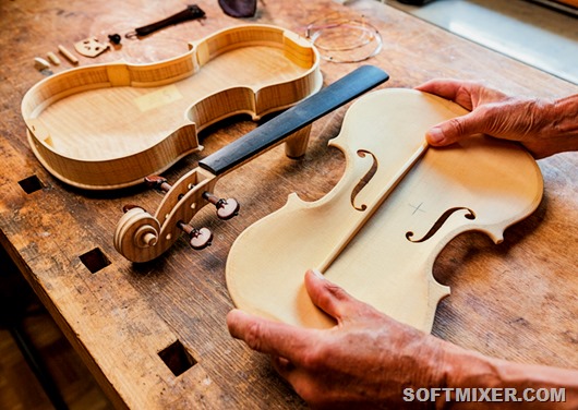 Elderly person building a violin