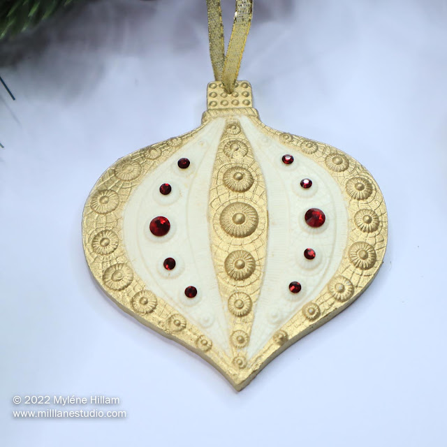 Ivory resin Christmas bauble with gold bands and red crystals