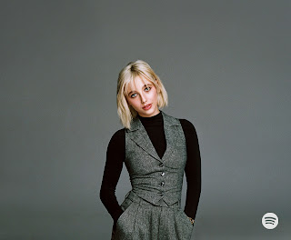 Photo of young blonde woman with hands in pockets