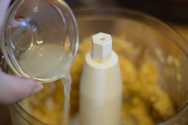 Lemon juice being added to the food processor. 