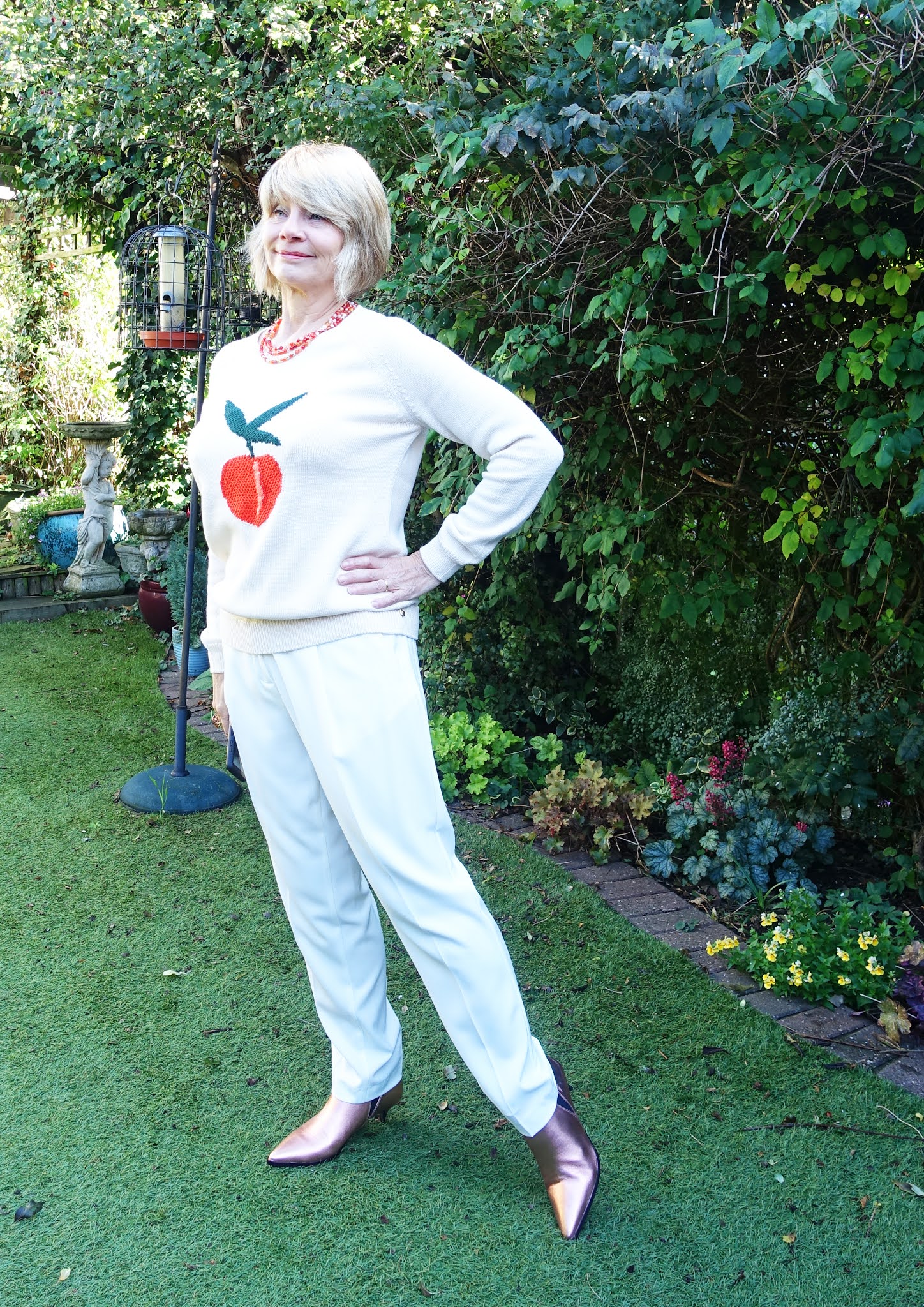 A fun but timeless look for Is This Mutton blogger Gail Hanlon in an all-cream outfit with a peach motif jumper and rose gold boots