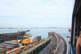 Dockside works at Staten Island ferry terminal with a distant view of the Manhattan skyline.  Travel photography by Kent Johnson.
