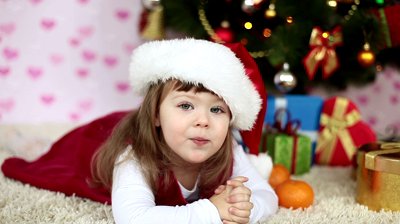 baby girl in a santa hat lying on the floor