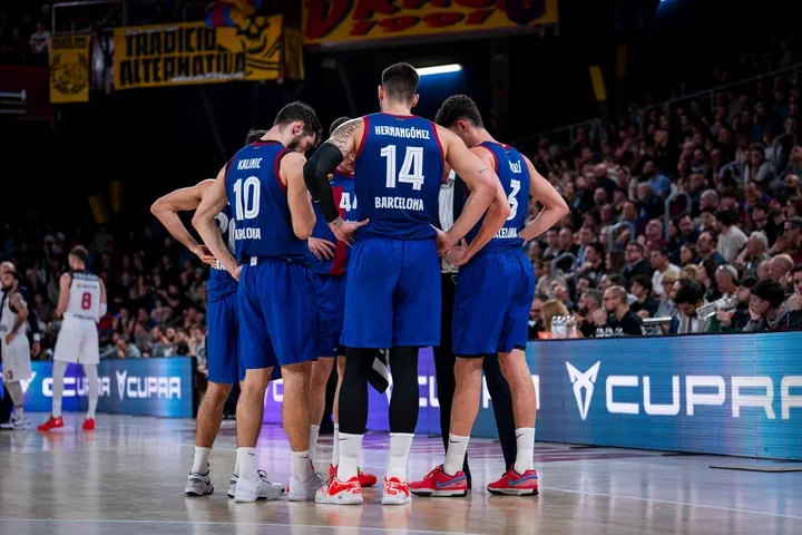 Barcelona squad huddle together during the game