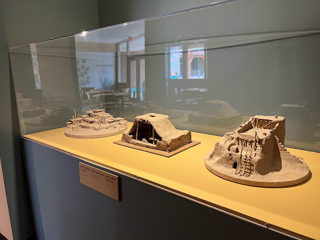 The development of the Pueblo dwellings over time. The middle model represents that pit house  which was underground. To the right is the single unit Acoma Pueblo and the left is the multi-story Zuni Pueblo.