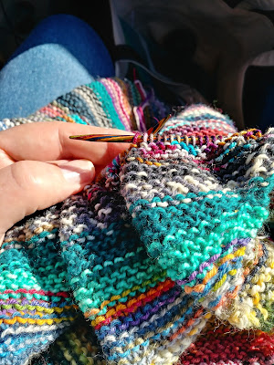 knitting a diagonal striped blanket with scrap sock yarn.