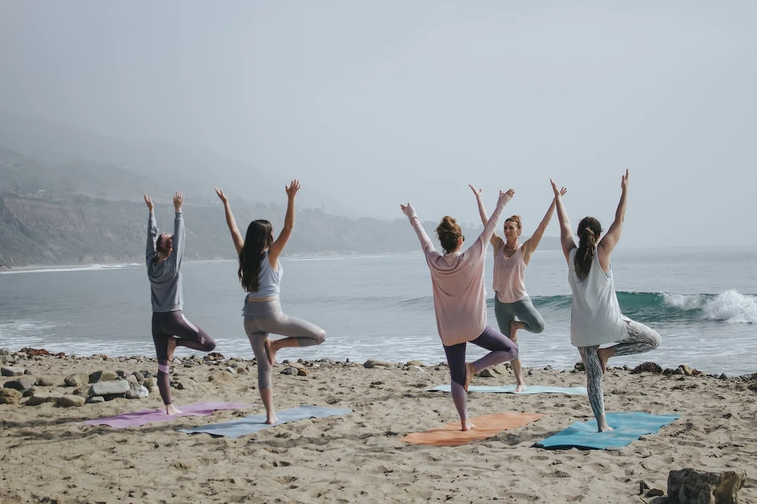 Girls Doing Yoga Pose on beach side wearing yoga pants