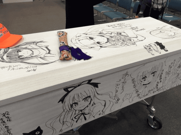 A coffin with anime girl drawing in tribute to a dead manga creator Tomohiru Matsu