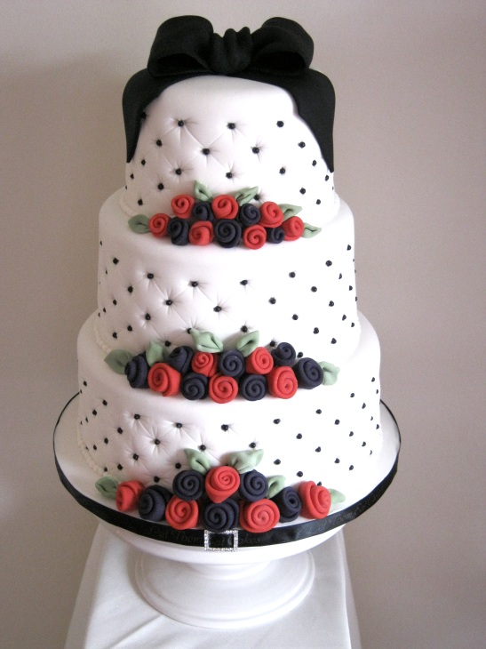A wedding cake to the bride's design with black deep purple and red as the