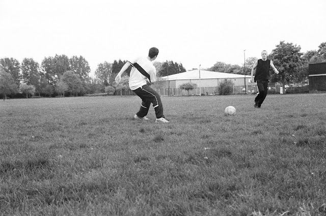 professional photograph of two men playing football in the park