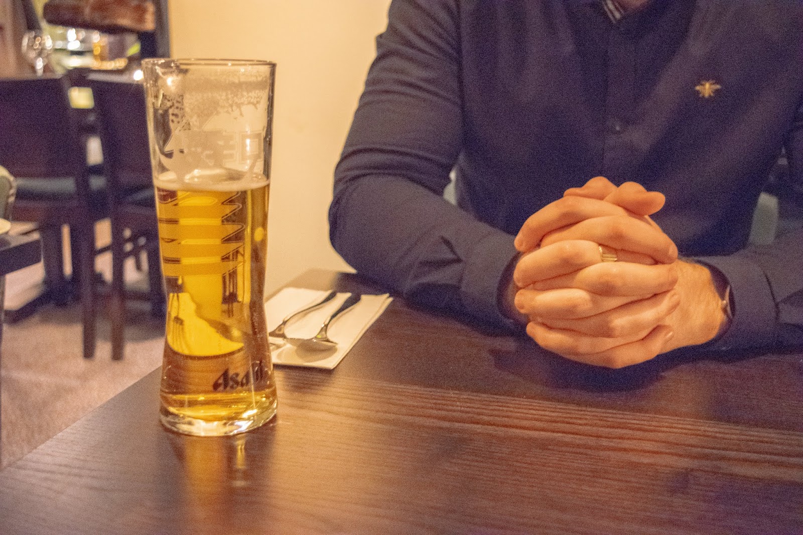 A tall draught beer glass with Asahi beer.