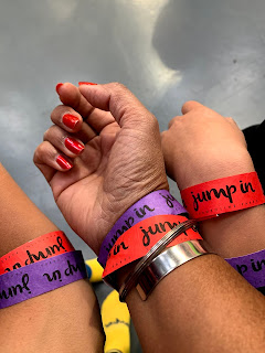 three hands display wristbands of different colours