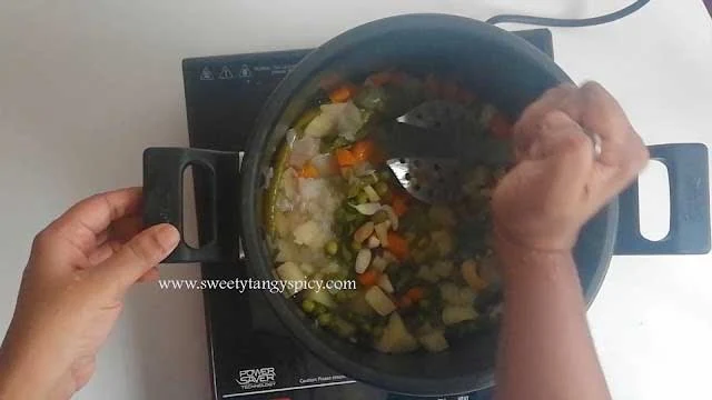 Gentle Mashing of Cooked Vegetables in Kerala Vegetable Stew Preparation