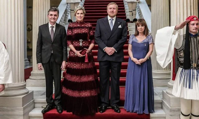 Queen Maxima wore a burgundy Lissie silk velvet gown by Costarellos. President of Greece Katerina Sakellaropoulou