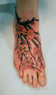vemos a una mujer con los pies desnudos , lleva un tatuaje en el pie 