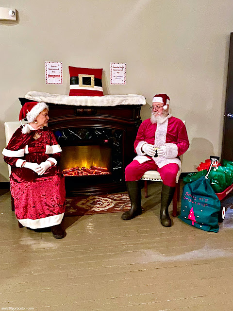 Santa y la Señora Claus en la Subasta de Árboles de Navidad