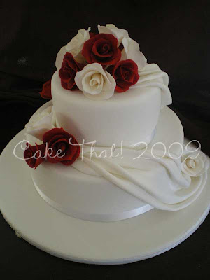 This two tier cake featured Burgundy roses and Ivory roses on a white cake