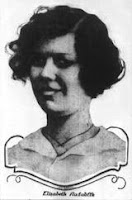 A headshot of a young woman with short, thick hair