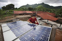 A woman inspects solar panels in the rural village of Tinginaput, India. (Credit: Abbie Trayler-Smith (Dfid)/Flickr) Click to Enlarge.