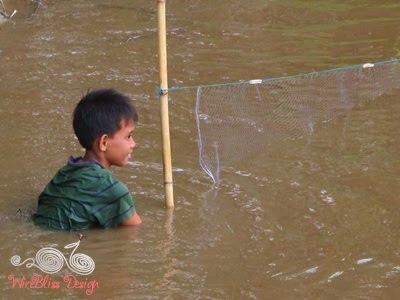 a boy tying his fishing net in place