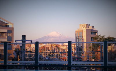 歩道の上から大きく見える、朝焼けの中の富士山。