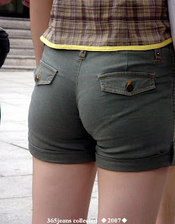 The young woman wearing jeans shorts in the edge of the road