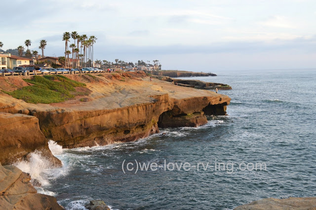 The setting sun casts a warm glow on the cliffs of Point Loma