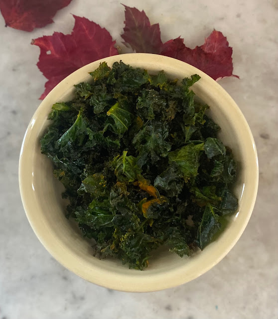 wilted kale in a bowl on a marble table with red leaves