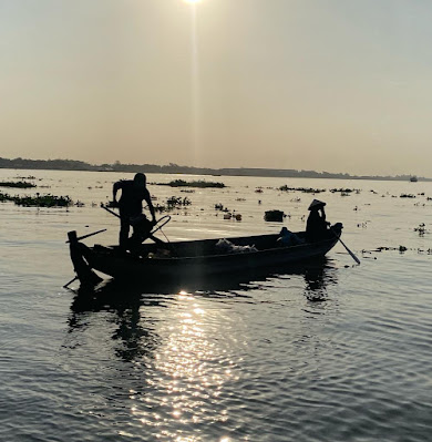 Two people in a small motorboat on the Mekong Delta near Can Tho, Vietnam.