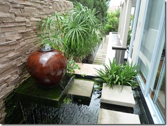 pot of over-flowing water that sits on a shelf for koi pond aeration