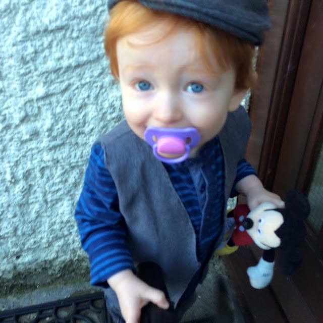 A red haired little boy dressed as a sweep