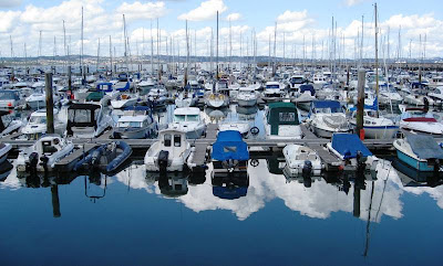 Boats in the marina and sky reflected in the still water