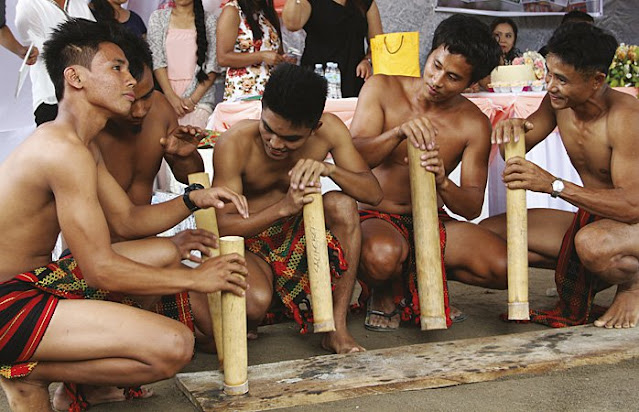 Kalinga men playing bamboo instruments at a wedding in Tabuk