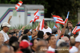 Miembros de brigadas solidarias con Cuba agitan banderas de Puerto Ric, en el Acto político cultural nacional por el aniversario 61 del asalto a los cuarteles Moncada y Carlos Manuel de Céspedes, realizado en el Mausoleo de los Mártires de Artemisa, el 26 de julio de 2014