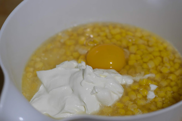 Egg added to the sour cream, corn, and jiffy mix in the bowl. 