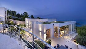 Modern villa looking out on the blue sea at the dusk