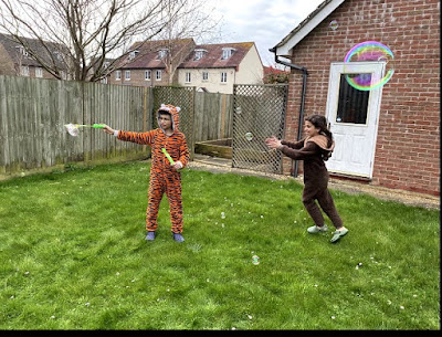 Children playing with bubbles in the garden